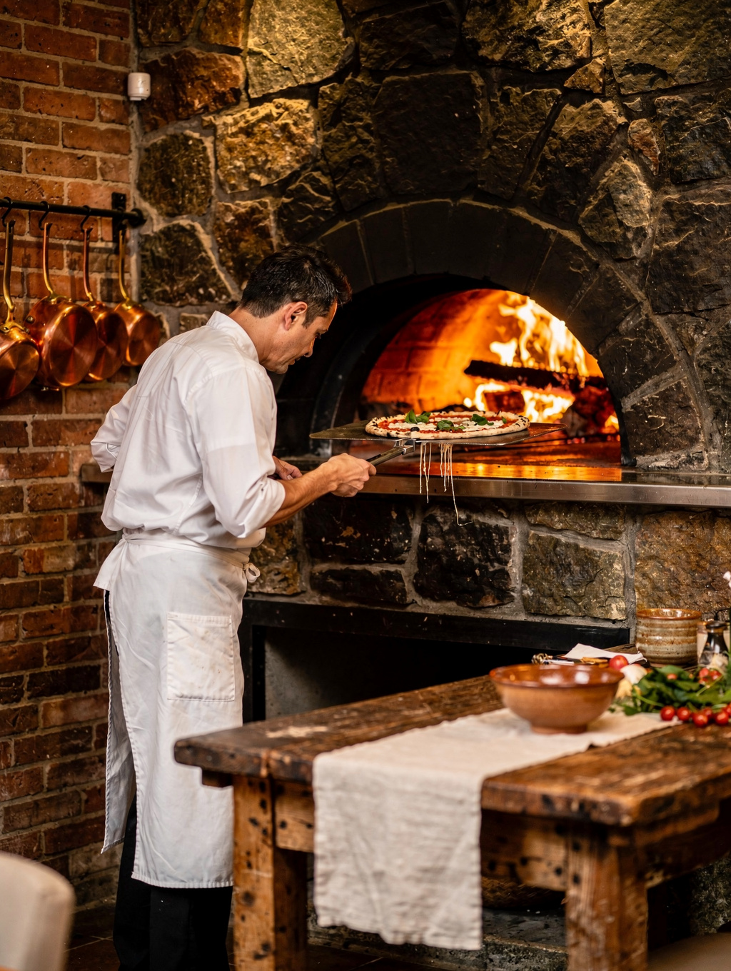 Chefs preparing dishes over the wood-fired open hearth